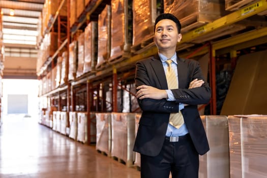Portrait of asian confidence businessman investor stand in large factory and distribution warehouse environment. Business owner and investment concept.
