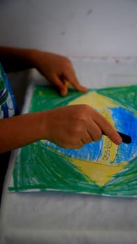 salvador, bahia / brazil - september 3, 2020: child paints pabeira do Brasil with crayons at his home in the city of Salvador.