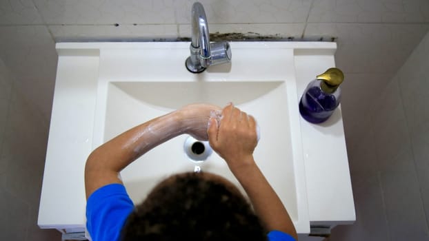 salvador, bahia / brazil - september 3, 2020: child is seen washing his hands in a bathroom sink in the city of Salvador.