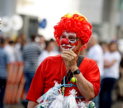 salvador, bahia / brazil - july 2, 2015: clown walks down the street of the Lapinha neighborhood during the Bahia independence parade in the city of Salvador.