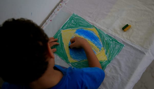 salvador, bahia / brazil - september 3, 2020: child paints pabeira do Brasil with crayons at his home in the city of Salvador.
