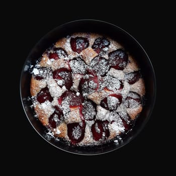 Whole plum pie on black background. Isolated with clipping path.