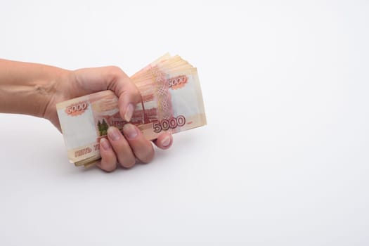 Hand holds a stack of five thousandth bills in a fist