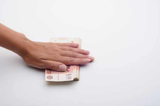The hand covered a stack of five thousandth bills on top