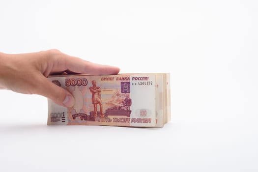 Hand holds a bundle of banknotes, five thousandth bills on a white background