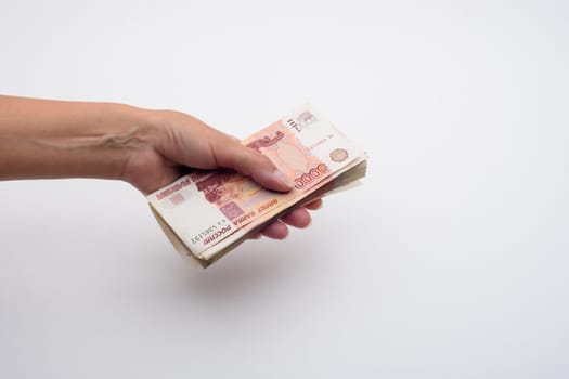 Hand holds out a stack of five thousandth bills