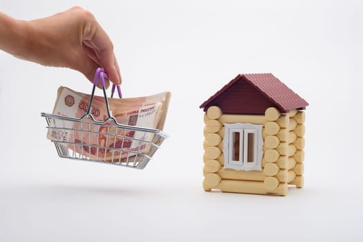 A hand brings a basket with a bundle of Russian five-thousandth bills to the house