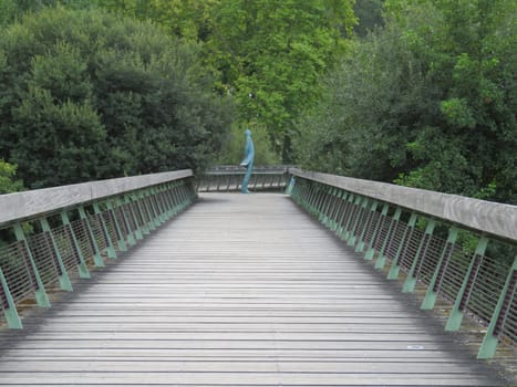 beautiful wooden walkway with an artistic figure in the background