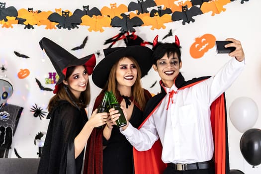 Group of friends asian young adult people celebrate a Halloween party carnival Festival. They wear Halloween costumes take selfie photographing. Halloween celebrate and international holiday concept.