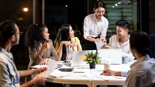 Work late concept of Interracial asian business team brainstorm idea at office meeting room at night. Work hard deadline and overtime working and new business start up concept.