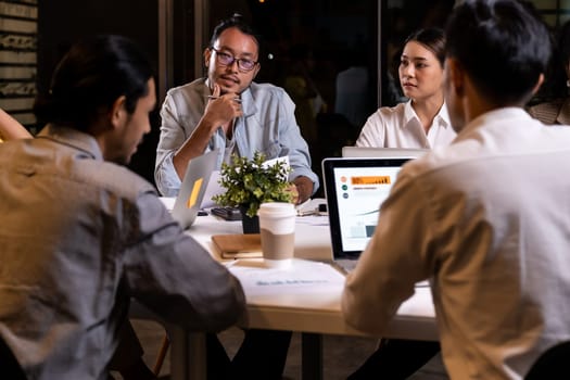 Work late concept of Interracial asian business team brainstorm idea at office meeting room at night. Work hard deadline and overtime working and new business start up concept.