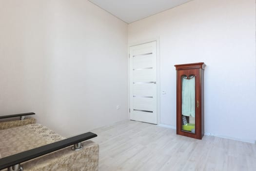 The interior of a modest small bedroom with very poor furniture