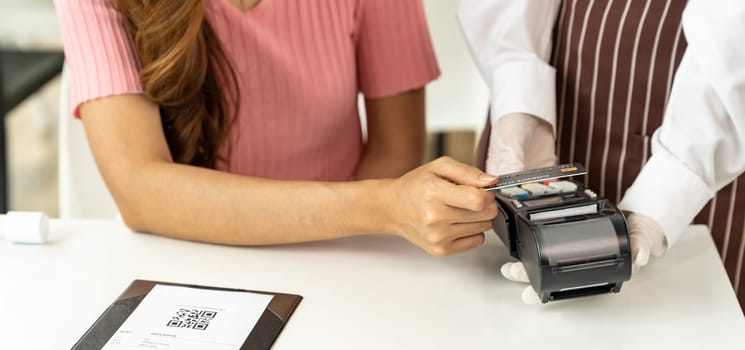 Panoramic Close up Asian woman customer make contactless credit card payment after eating out in new normal social distance restaurant to reduce touching. Online contactless and technology concept.