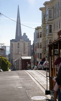 A San Francisco Trolly moves people along with Trans America Tower in the background