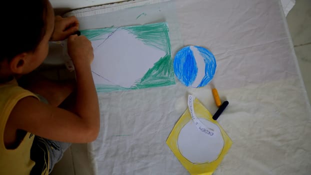 salvador, bahia / brazil - september 3, 2020: child paints brazil flag with crayons at his home in the city of Salvador.