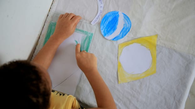 salvador, bahia / brazil - september 3, 2020: child paints brazil flag with crayons at his home in the city of Salvador.
