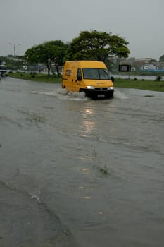 eunapolis, bahia / brazil - april 9, 2009: vehicle transits in flooded area on highway BR 101 in the city of Eunapolis, in southern Bahia..