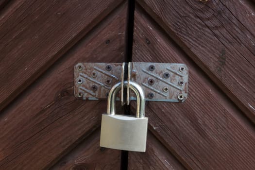Metal padlock on the gate. Closed door with padlock