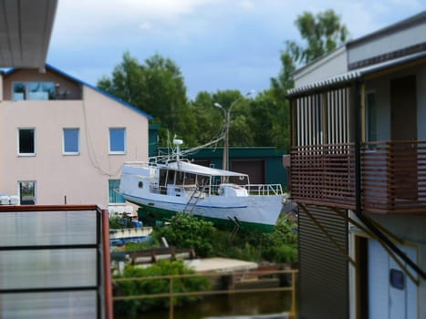fishing boat on the shore among houses, rural landscape tilt film
