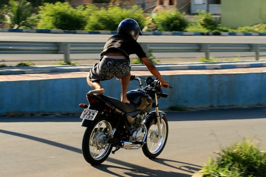 eunapolis, bahia / brazil - january 15, 2009: motocilcista is seen standing while the vehicle is traveling on the BR 101 highway in the city of Eunapolis.