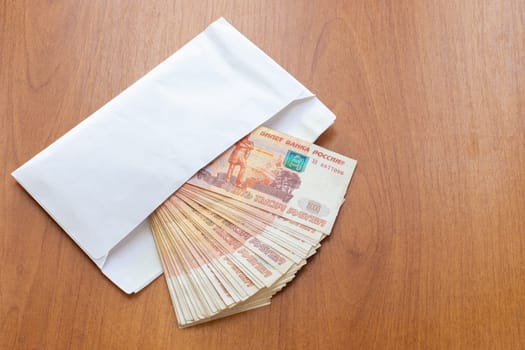 There is a bundle of money in an envelope on the table