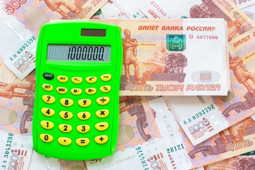 The number 1,000,000 is written on the calculator, the calculator lies on a pile of money