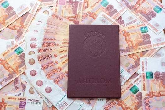 Against the background of five-thousandth bills is a red diploma with honors