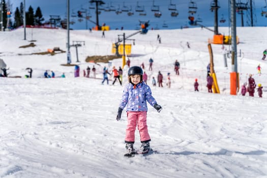 Young happy skier girl learning how to ski on the green ski zone. Young skier having fun on ski slope, Bialka Tatrzanska, Tatry, Poland