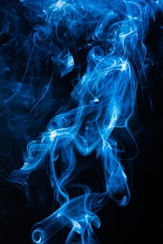 Blue abstract shaped smoke against black background. Abstract background. Selective focus