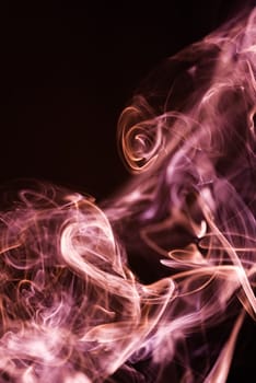 Red abstract shaped smoke against black background. Abstract background. Selective focus