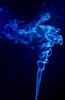 Blue abstract shaped smoke against black background. Abstract background. Selective focus