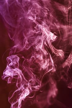 Red abstract shaped smoke against black background. Abstract background. Selective focus