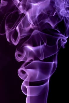 Violet abstract shaped smoke against black background. Abstract background. Selective focus