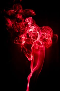 Red abstract shaped smoke against black background. Abstract background. Selective focus