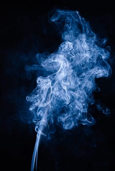 Blue abstract shaped smoke against black background. Abstract background. Selective focus