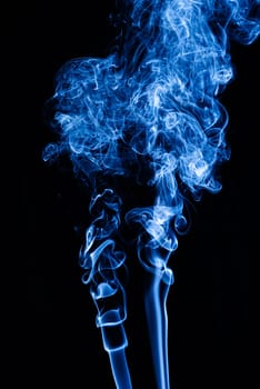 Blue abstract shaped smoke against black background. Abstract background. Selective focus