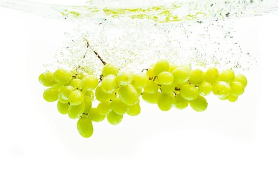 Fresh green grapes in water against white background. Health concept.
