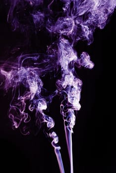 Violet abstract shaped smoke against black background. Abstract background. Selective focus