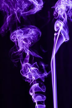 Violet abstract shaped smoke against black background. Abstract background. Selective focus