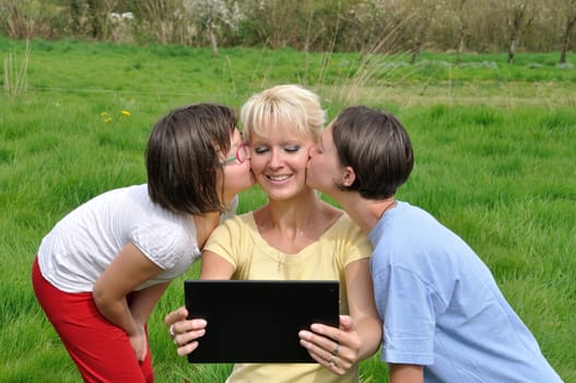Family sitting on the lawn and using digital tablet