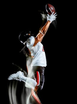 one african american football player man studio shot isolated on black background with light painting with blurred motion speed effect