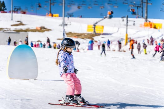 Young happy skier girl learning how to ski on the green ski zone. Young skier having fun on ski slope, Bialka Tatrzanska, Tatry, Poland
