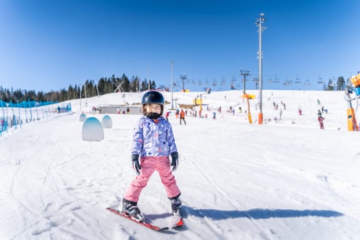 Young happy skier girl learning how to ski on the green ski zone. Young skier having fun on ski slope, Bialka Tatrzanska, Tatry, Poland
