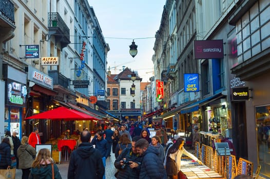 BRUSSELS, BELGIUM - OCTOBER 06, 2019: Crowd of people walking by Old Town shopping street of Brussels at twilight