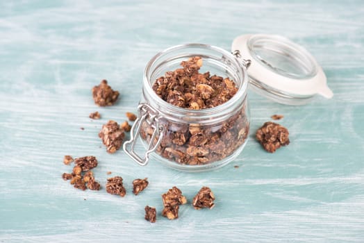 Muesli with chocolate on a turquoise blue and white background, empty copy space