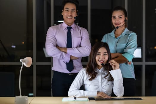 Late Night Environment, Portrait of friendly Call centre operator team with headsets in a call center customer service and technical support. Using for 24 Hr. Call center Concept.