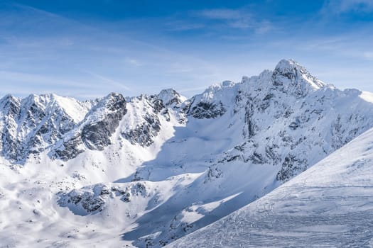 View from Kasprowy Wierch at Swinica mountain peak at winter. Amazing mountain range with snow capped mountain peaks in Tatra Mountains, Poland