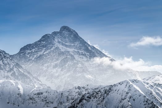 View from Kasprowy Wierch at rocky mountain peak at winter. Amazing mountain range with snow capped mountain peaks in Tatra Mountains, Poland