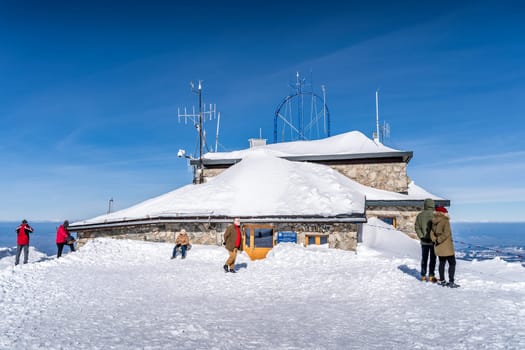 Zakopane, Poland March 2019 Tourists sightseeing the tope of Kasprowy Wierch with multiple meteorologic station in background
