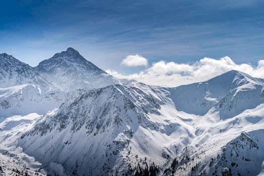 View from Kasprowy Wierch at Swinica mountain peak at winter. Amazing mountain range with snow capped mountain peaks in Tatra Mountains, Poland